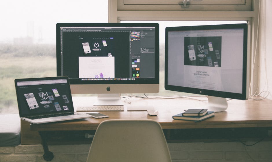 Stylish and efficient workspace with multiple monitors, laptop, and smartphone, showcasing a web design project